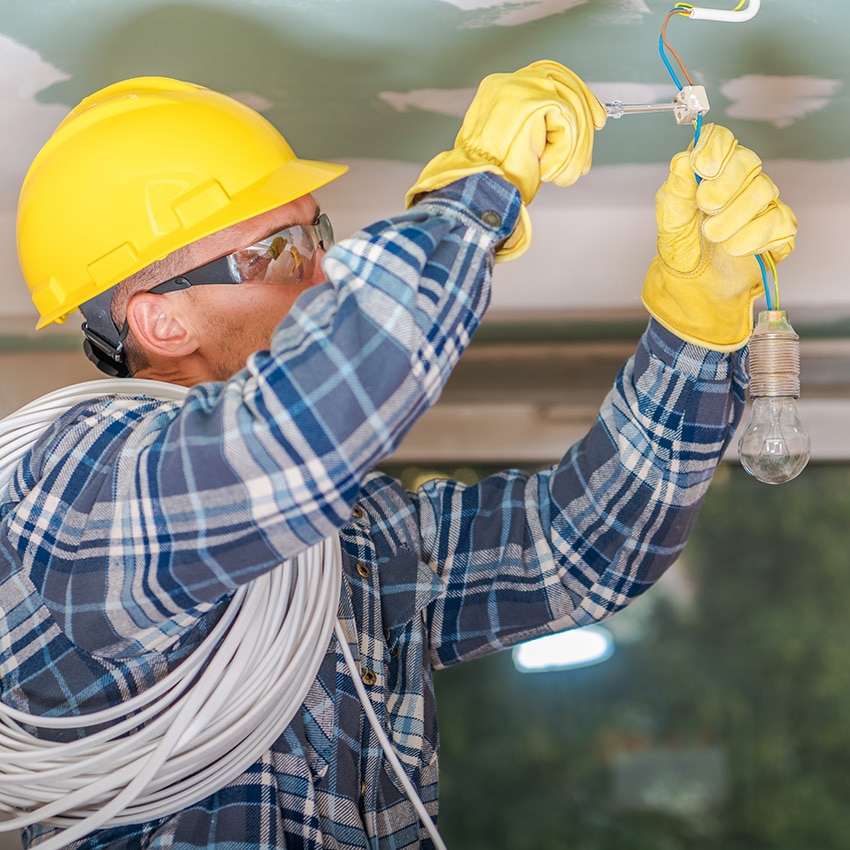 An image of an electrician working on a residential project with wires in the ceiling.