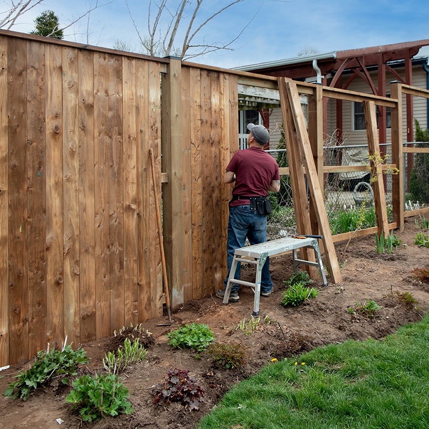 An image of a fence contractor working on a residential fence job.