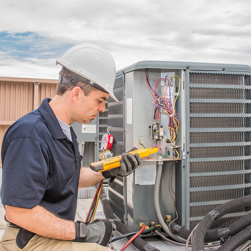 An image of an HVAC contractor working on an AC repair