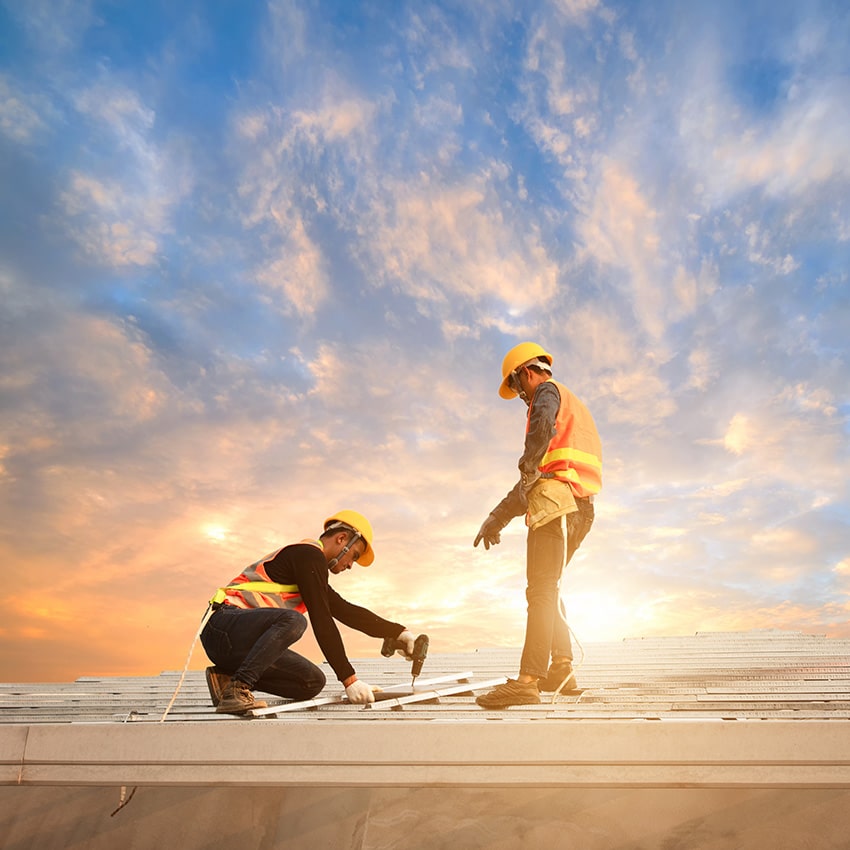 An image of two roofers actively working on a roof.
