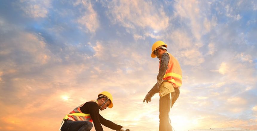 An image of two roofers actively working on a roof.